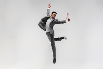 Happy businessman dancing in motion isolated on white studio background. Flexibility and grace in...