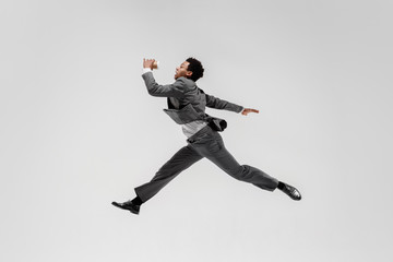 Obraz na płótnie Canvas Happy businessman dancing in motion isolated on white studio background. Flexibility and grace in business. Human emotions concept. Office, success, professional, happiness, expression concepts