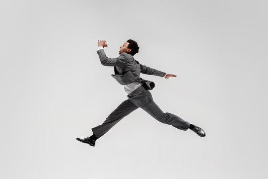 Happy businessman dancing in motion isolated on white studio background. Flexibility and grace in business. Human emotions concept. Office, success, professional, happiness, expression concepts