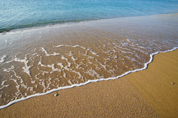 Graphic composition drawn by the sea on the golden and unique sand of Lia beach in Mykonos