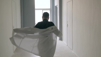 Doctor puts dressing gown on the go - Powered by Adobe