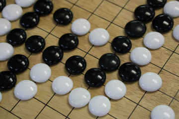 Go. Traditional asian strategy board game.  black and white stone of Chinese go game board.
