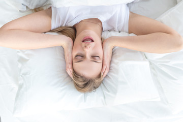 attraactive girl singing a song while resting in the bed, top view photo