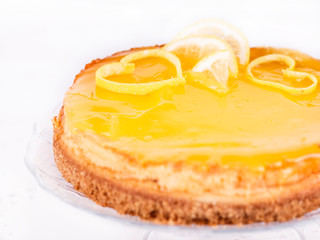 Lemon cheesecake on white background decorated with lemon zest close up