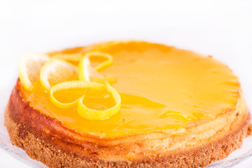 Lemon cheesecake on white background decorated with lemon zest close up
