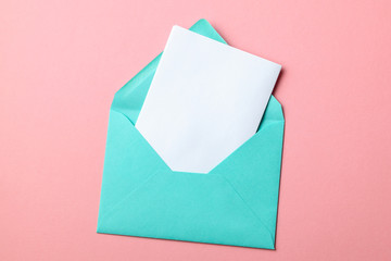 Green envelope and blank letter on pink background