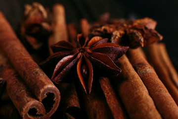 Spices sticks cinnamon and star anise on the old table. Rustic dark background, aroma close-up, macro.