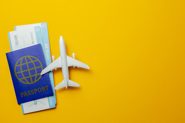 Tickets for plane and passport with model of passenger plane on yellow background. Copy space for...