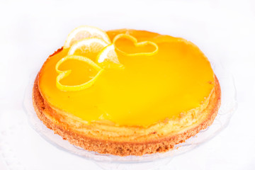 Lemon cheesecake on white background decorated with lemon zest close up