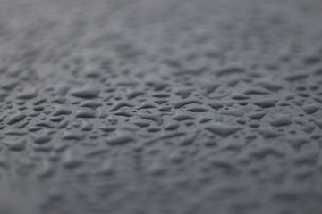 large drops on the surface of a gray car