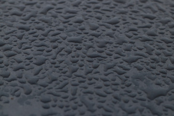 large drops on the surface of a gray car