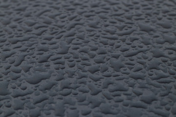 large drops on the grey metal roof of the car