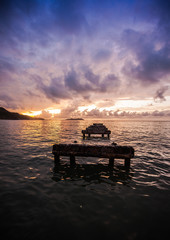 Naklejka na ściany i meble Wooden pier at sea with a dramatic sunset