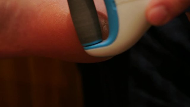 using electric foot file, grater for feet, heels