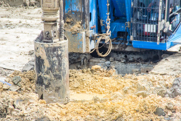 Fototapeta na wymiar Hydraulic drilling machine is boring holes in the construction site for bored piles work. Bored piles are reinforced concrete elements cast into drilled holes, also known as replacement piles.