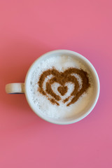 Heart Shape Coffee Cup Concept isolated on pink background. love cup , heart drawing on latte art coffee. vertical photo