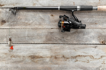 Fishing tackle - fishing spinning, hooks and lures on old wood background