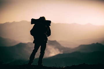 Silhouette of tourist with backpack standing on the mountain. travel concept.