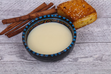 Condenced milk in the bowl with sinnamon and pastry