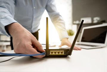 Man connects the cable to the router's socket