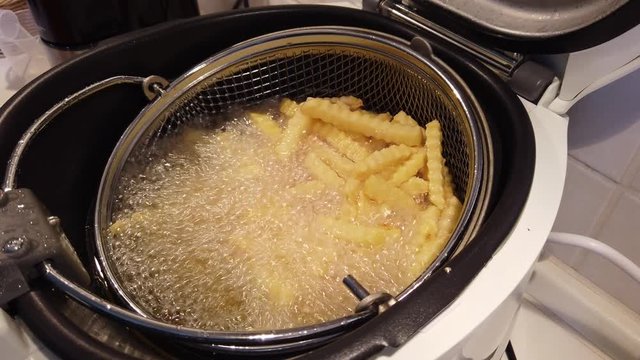 Pommes in einer drehenden Friteuse