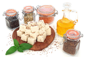 Vegan health food with tofu bean curd, flax, alfalfa, hemp and chia seeds, lentils, basil herb, olive oil and peppercorns on white background. Super foods high in protein and omega 3.