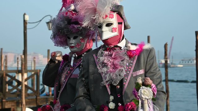 Venice - carnival masks are photographed with tourists in Piazza San Marco