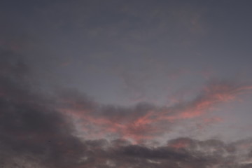 Fototapeta na wymiar Evening sky during february with red purple violet sun light and clouds