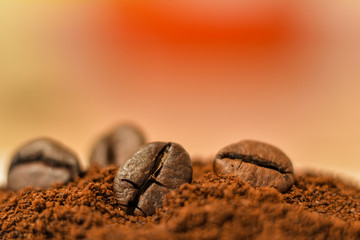 Ground coffee and whole grains of coffee close-up.