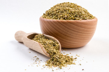 oregano herb in wooden bowl and scoop isolated on white background
