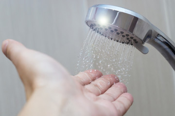 Obraz na płótnie Canvas hand in the shower test water temperature