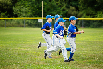 Young baseball players running 