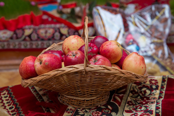 Basket with red apples with autumn leaves, closeup . Red apples in the basket .