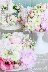 Floral arrangement with pink peonies, tiny roses, chrysanthemums and gypsophila paniculata twigs.