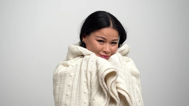 Lovely Asian woman getting warm wrapped in white scarf