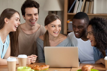 Smiling multiracial people using laptop together, having fun