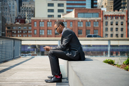 Man wearing suit,  sitting on ledge, , 