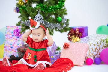 Obraz na płótnie Canvas Baby in a christmas dress sitting