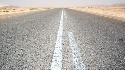 Asphalt road straight in the desert in the south of Oman