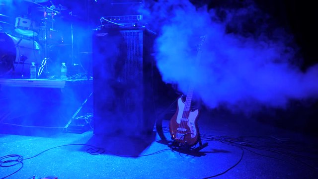 Guitar background. Electro guitar left on the stage. Smoke at the concert. Music lights at nightclub, concert, festival. Recording studio music store advertisement. Concert background. Rock concert