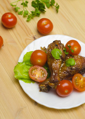 drumstick chicken in soy sauce with cherry tomatoes and sesame in on wooden 