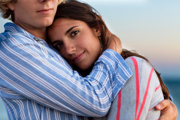 Young man hugging girlfriend on beach