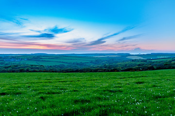 Evening time over fields of grasss and trees in Cornwall