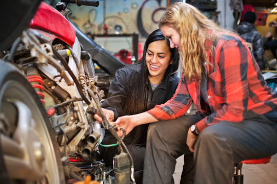 Female mechanics repairing motorcycle 