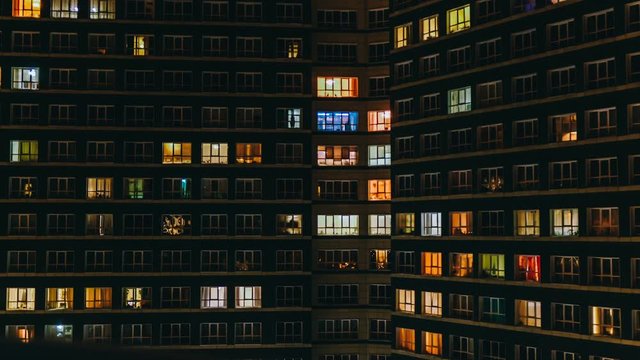 Time lapse of apartment building at night. Timelapse of residential flats windows lighting up and turning off overnight