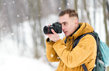 Photograph boy shooting winter landscapes while walking in the forest