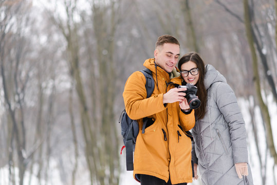 Couple of tourists standing and looking photo at the camera while walking in the forest