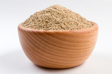 ground white pepper in wooden bowl isolated on white background.
