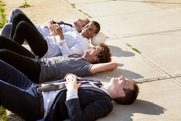 Four friends lying on pavement and talking 