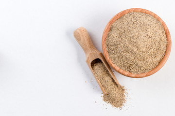 ground white pepper in wooden bowl and scoop isolated on white background with copy space added. top view